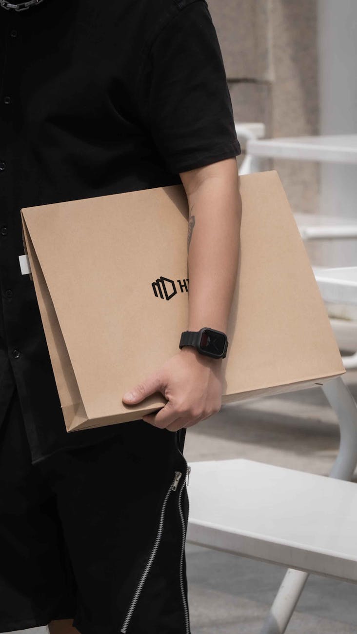 Photo by SU JI | via Pexels | License: Pexels License | https://www.pexels.com/photo/paper-bag-carried-by-a-man-with-a-smartwatch-27075533/