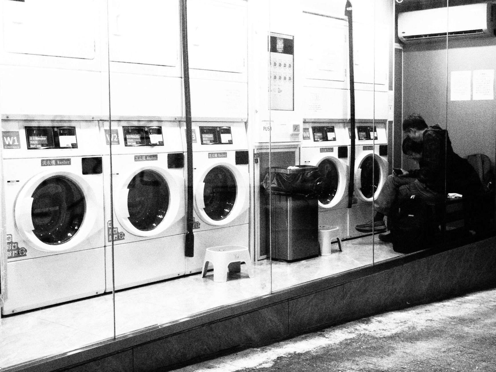 Photo by terry narcissan tsui | via Pexels | License: Pexels License | https://www.pexels.com/photo/black-and-white-urban-laundromat-scene-in-hong-kong-34409198/