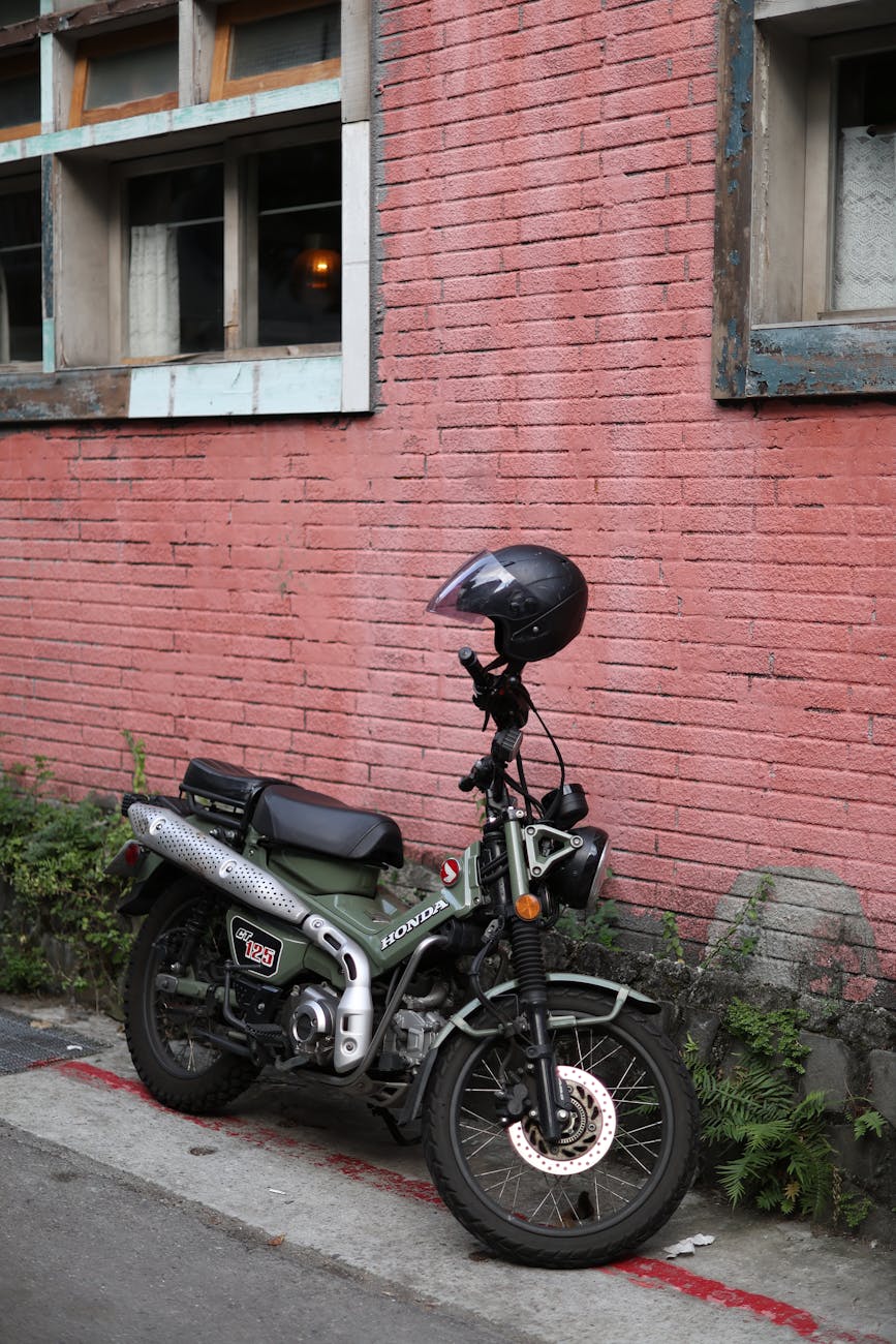 Photo by 慶文 施 | via Pexels | License: Pexels License | https://www.pexels.com/photo/green-motorcycle-parked-by-pink-brick-wall-in-taipei-35028740/