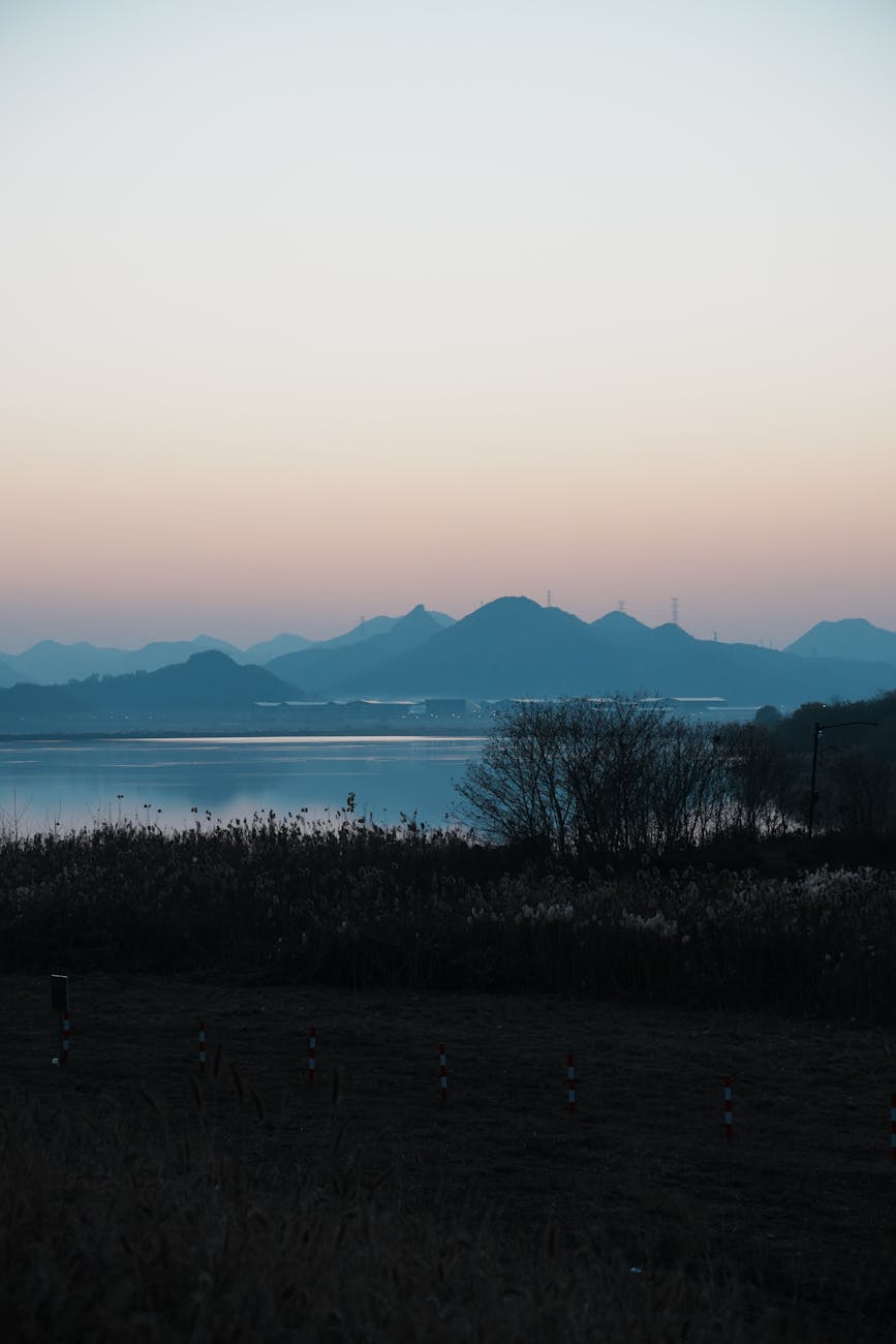 Photo by Leila Chen | via Pexels | License: Pexels License | https://www.pexels.com/photo/serene-sunset-over-tranquil-lake-and-silhouetted-mountains-35416975/