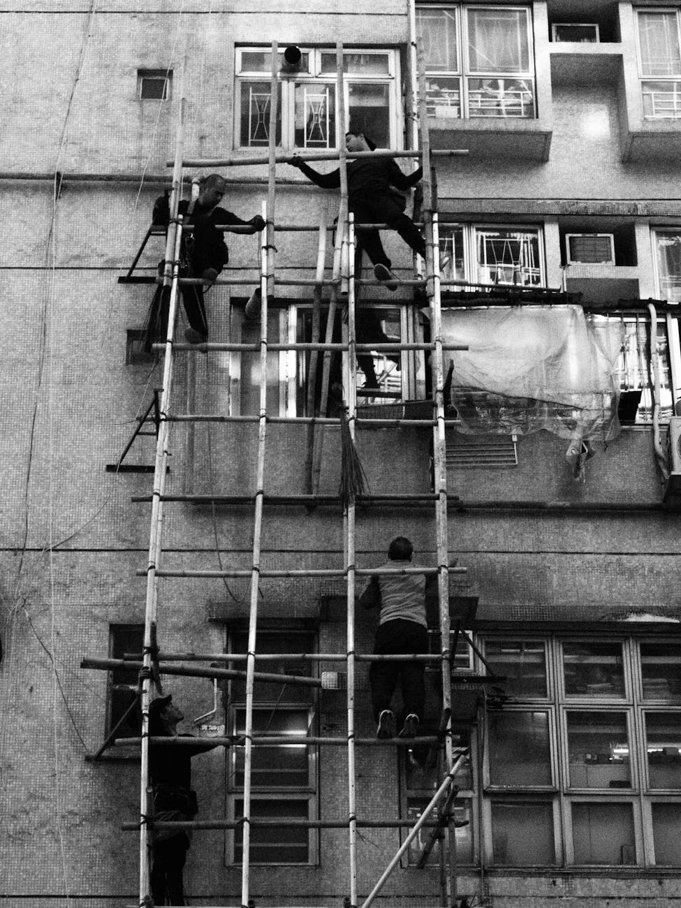 Photo by terry narcissan tsui | via Pexels | License: Pexels License | https://www.pexels.com/photo/construction-workers-on-bamboo-scaffolding-in-hong-kong-35575553/